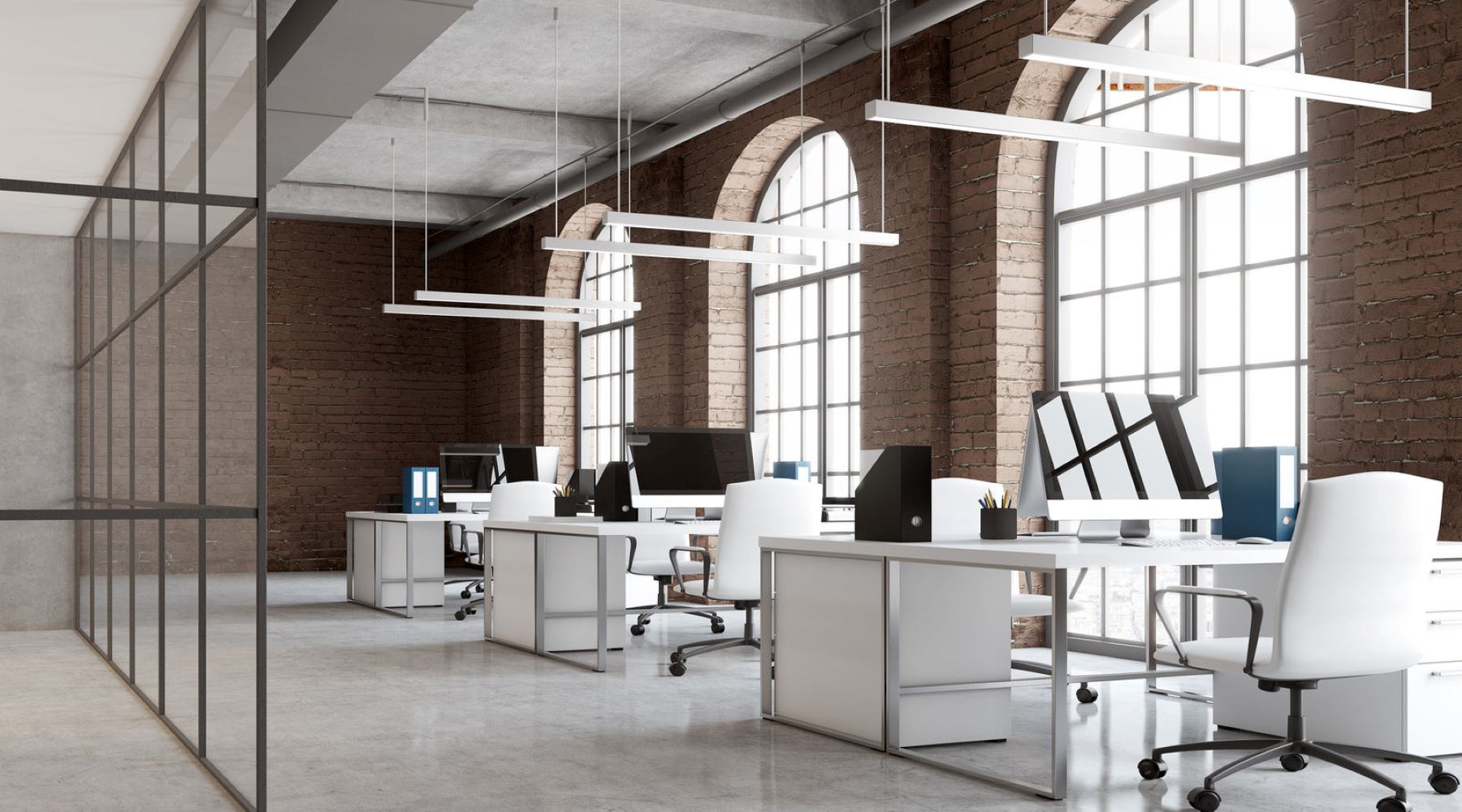 Commercial lighting fixtures installed above desk in brick office with arch windows